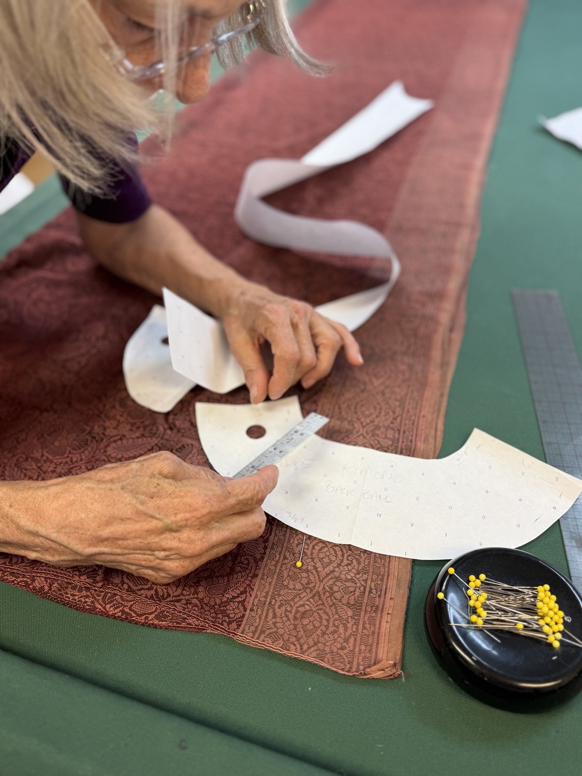 Measuring a neckline pattern against the sari border